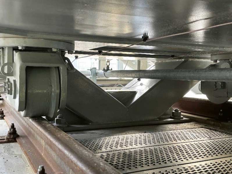 <b>Bild 8</b> Erd­beben­veran­kerung mit Zwischenstück von Fundament zu Kessel. Zudem ist eine Lösch­wasser­leitung und ein wärme­empfin­dliches Kabel der Löschanlage sichtbar.