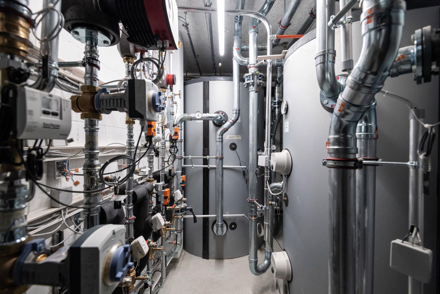 Chacun des trois immeubles est doté d’un local technique avec un monobloc pour la ventilation, la pompe à chaleur eau/eau, le module pour eau chaude sanitaire et le chauffe-eau technique utilisé en hiver pour le chauffage au sol et l’eau chaude sanitaire. En été, les appartements sont refroidis d’environ 3°C par le biais du free cooling. La chaleur extraite est emmagasinée dans le réservoir de stockage thermique (d’une capacité totale de 10’500 l pour les trois immeubles).