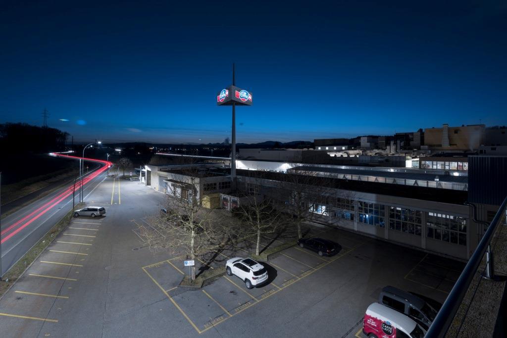 Freundliches Licht auf dem Besucherparkplatz von Emmi, der vor allem tagsüber gebraucht wird. Das Licht muss deshalb nicht bis in jede Ecke reichen.