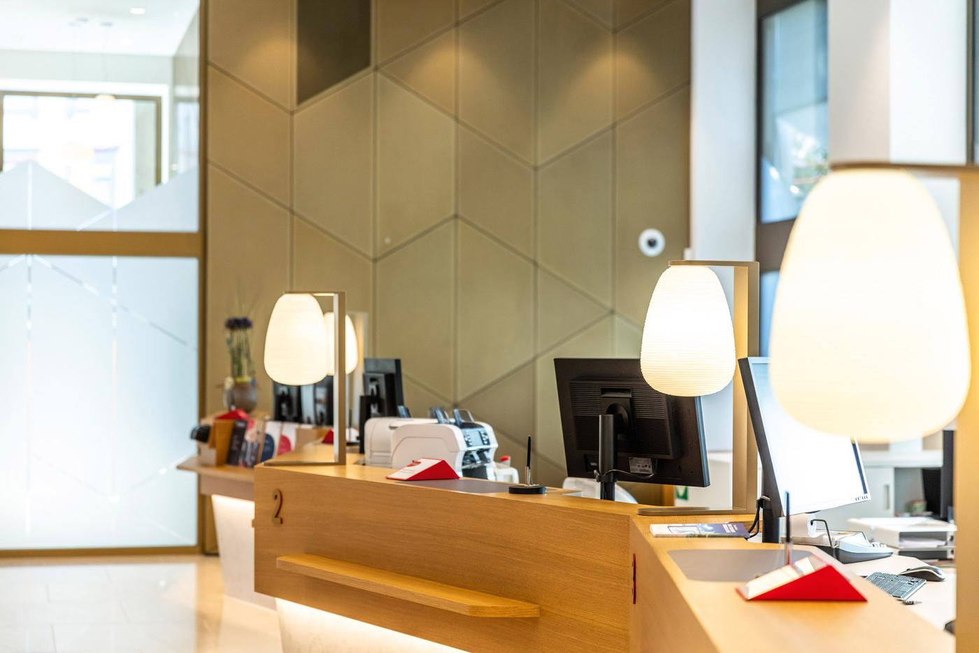 Des lampes décoratives cachent les écrans dans la salle des guichets.