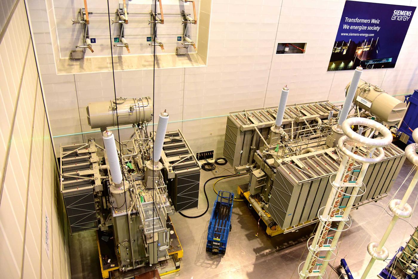 <b>Bild 7</b> Aufstellung eines Längsregulier-Transformators (rechts) und Querregulier-Transformators in der Prüfhalle im Herstellerwerk Weiz von Siemens Energy. Im Unterwerk Mettlen wird es sieben solcher Transformatorengruppen geben.